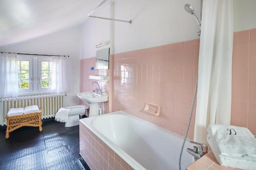 różowa łazienka z wanną i umywalką w obiekcie Maison Dominxenea w Sare