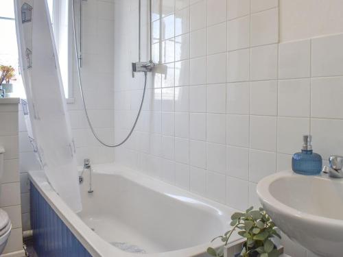 a white bathroom with a tub and a sink at Seashell House in Burnham on Sea