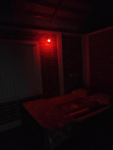 a dark room with a red light on the wall at Gruham Malpe Homestay Udupi in Malpe