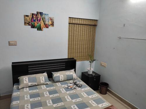a bedroom with a bed and a picture on the wall at Gruham Malpe Homestay Udupi in Malpe