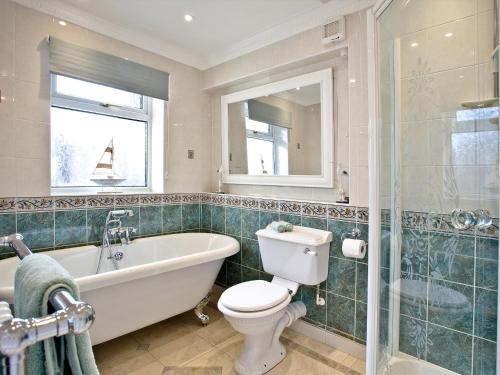 a bathroom with a tub and a toilet and a sink at Sea Salt Lodge in Torquay