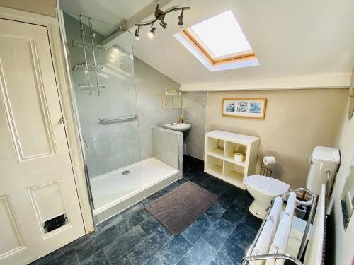 a bathroom with a shower and a toilet and a sink at The Coach House - 26154 in Corbridge