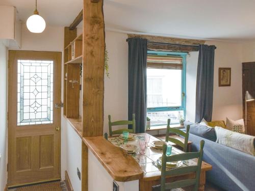 een keuken en een woonkamer met een tafel en stoelen bij Berkeley Cottage in Ilfracombe