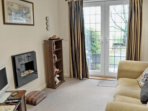a living room with a couch and a fireplace at Whitethorn Lodge in Skipton