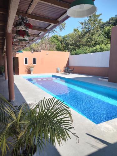 a swimming pool in front of a house at Villas victoria mirador in Zihuatanejo