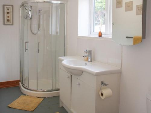 Long Stratton的住宿－Haycart Barn，白色的浴室设有水槽和淋浴。