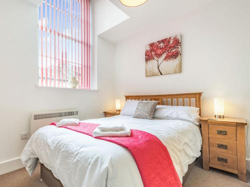 - une chambre avec un lit et une couverture rouge dans l'établissement Shire Cottage - Uk37451, à Pateley Bridge