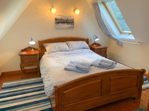 a bedroom with a wooden bed with two night stands at The Byre Cottage in Kirkcudbright
