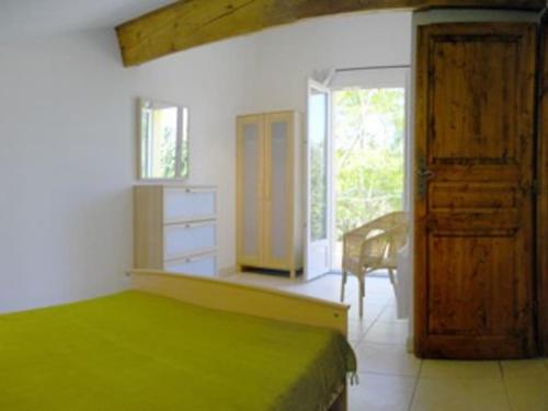 - une chambre avec un lit, un bureau et une porte dans l'établissement La Pinede, à Bellegarde-du-Razès