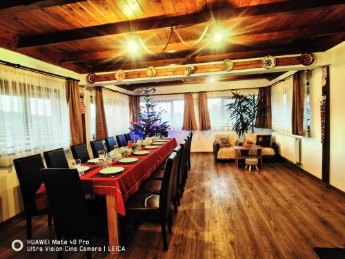 a large dining room with a long table and chairs at Vatra Strabunilor in Moigrad