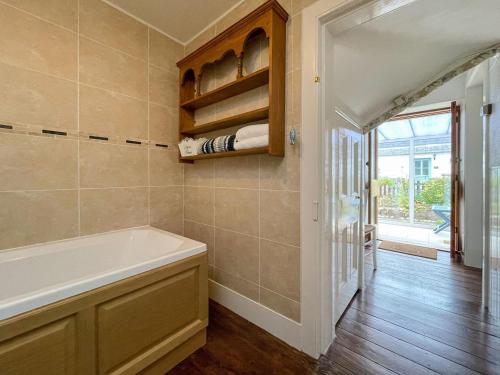 a bathroom with a bath tub in a room at Pink Cottage in Nairn
