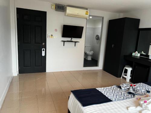 a bedroom with a bed and a tv on the wall at Golden Monkey Samui in Koh Samui 