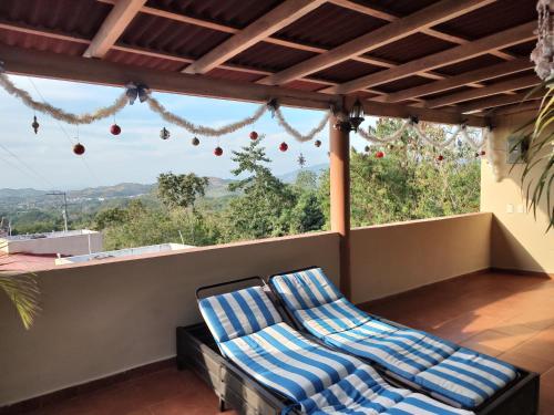 two blue chairs sitting on a balcony with a view at Villas victoria mirador in Zihuatanejo