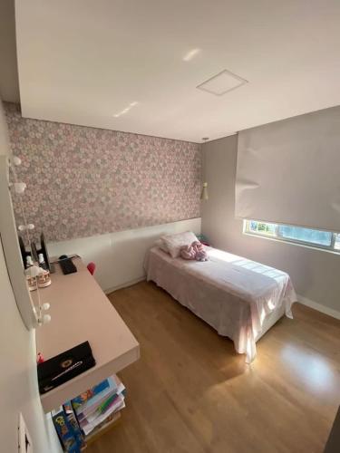 a small bedroom with a bed and a desk at ENCANTADOR , MODERNO E CONFORTÁVEL !!! in Belo Horizonte