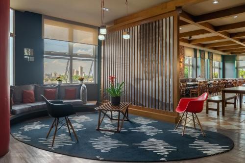 a lobby with chairs and a couch and tables at ibis Sorocaba in Sorocaba
