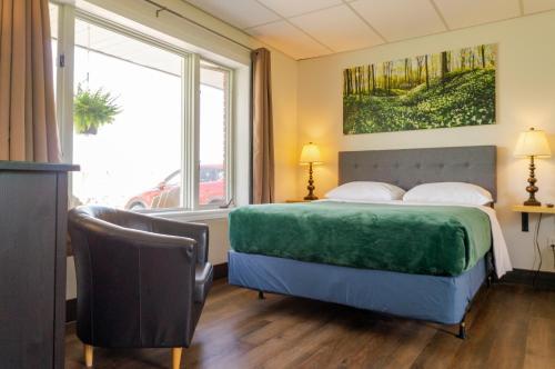 1 dormitorio con cama y ventana grande en Wayside Motel Manitoulin en Manitowaning