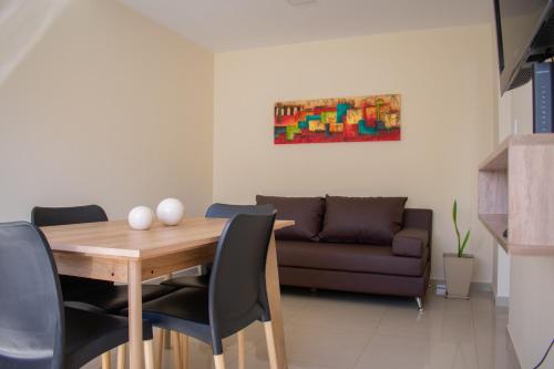 comedor con mesa y sofá en Departamento Solares de Cofico - Terraza Privada en Córdoba