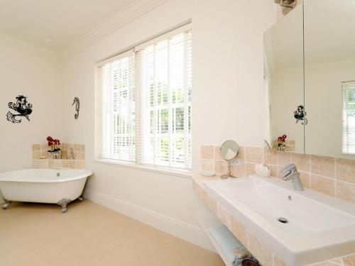 La salle de bains blanche est pourvue d'une baignoire et d'un lavabo. dans l'établissement Hearts Ease home, à Governorʼs Harbour