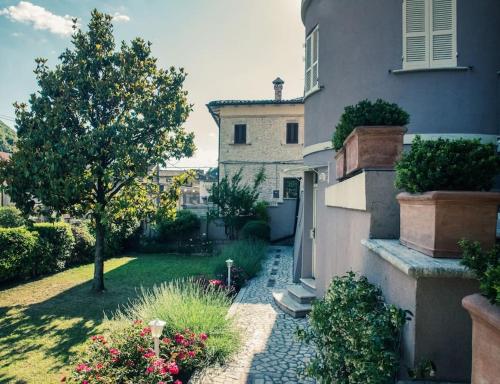 una casa con un cortile con un albero e fiori di Appartamenti LA MAGNOLIA ad Arrone