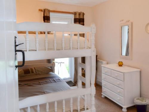 a bedroom with two bunk beds and a dresser at Barn Cottage - Ukc2682 in Poundstock