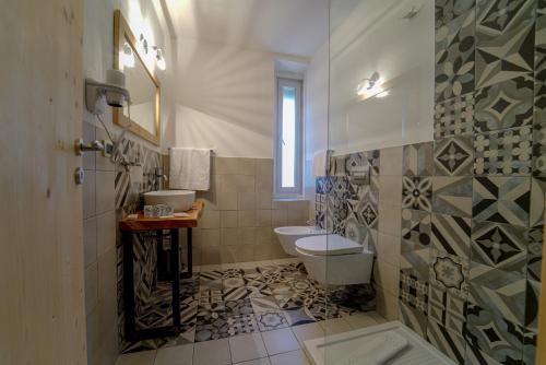 ein Bad mit einem WC und einem Waschbecken in der Unterkunft GH Hotel Monzoni in Pozza di Fassa