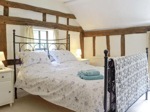 ein Schlafzimmer mit einem Bett und einem blauen Handtuch darauf in der Unterkunft Meadow Cottage in Chediston