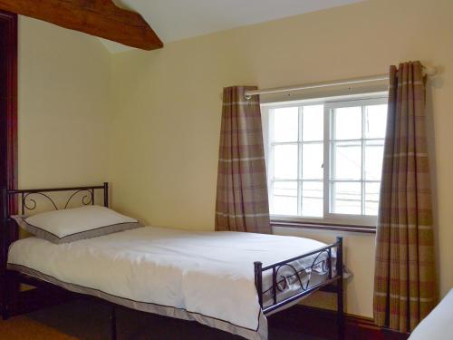 a small bedroom with a bed and a window at Repton Cottage - 25348 in Findern