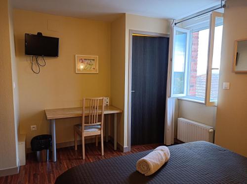 - une chambre avec un bureau, un lit et une fenêtre dans l'établissement Les Pierres Folles, à Rozier-en-Donzy