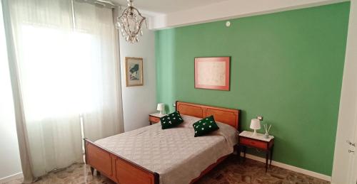 1 dormitorio con cama y pared verde en La Casa di Amelie, en Parma