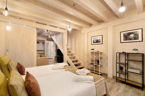 a bedroom with a large bed and a staircase at Casa na Travessa in Faro