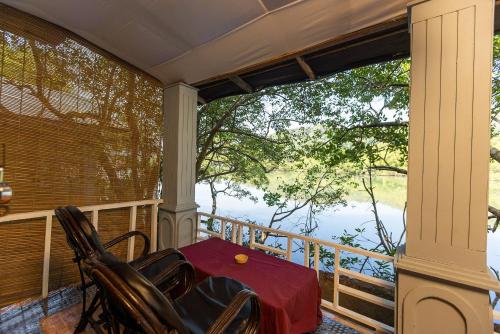 a porch with a table and chairs on a balcony at Dreamcatcher By Brifton Hotel And Resorts in Palolem