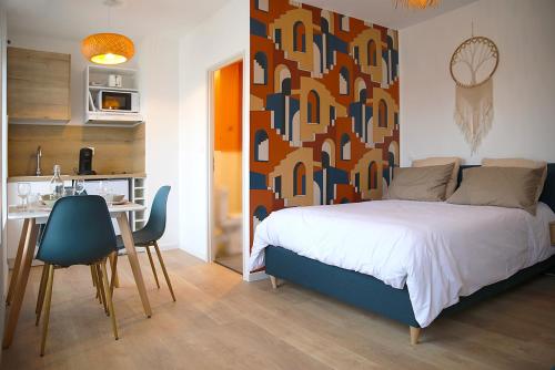 une chambre avec un lit et une table et une cuisine dans l'établissement Coco Beach, à Calais