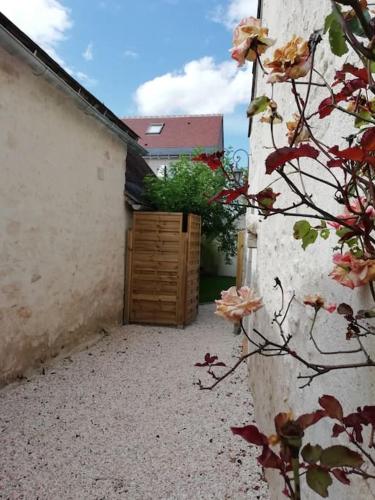 un patio con puerta de madera en un edificio en Charmante maison de village en Val de Loire, en Rivarennes