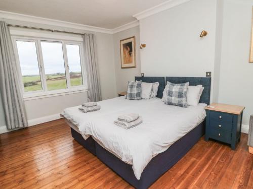 a bedroom with a large bed with two towels on it at Glenander in Bamburgh