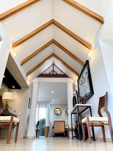 a living room with a vaulted ceiling with a table and chairs at Piece of Paradise in the city in Guadalajara