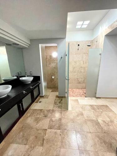a bathroom with two sinks and a walk in shower at Piece of Paradise in the city in Guadalajara
