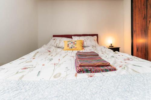 Una cama blanca con una manta encima. en Lewes Guest Nest, en Lewes