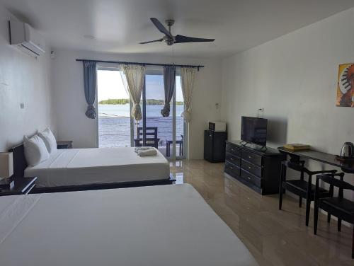 a bedroom with a bed and a desk and a television at Inn The Town in Port Antonio