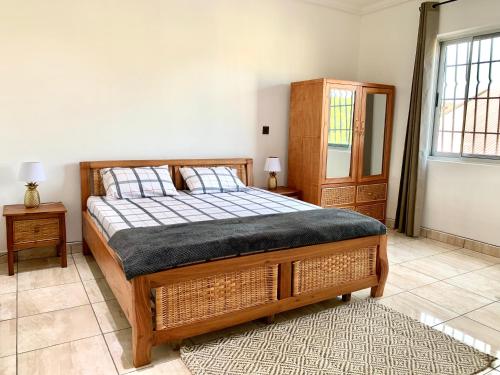 a bedroom with a bed and a cabinet and a rug at The Dzorwulu Castle - A Villa with private rooms in Accra