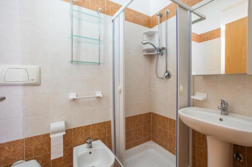 uma casa de banho com um chuveiro, um lavatório e um WC. em One Love apartments em Lupetto