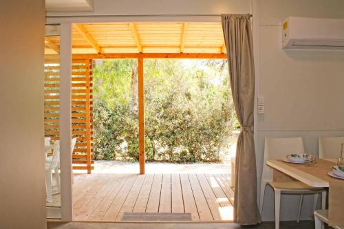 een open deur naar een patio met een tafel en stoelen bij Villaggio Camping Sentinella in Torre dell'Orso