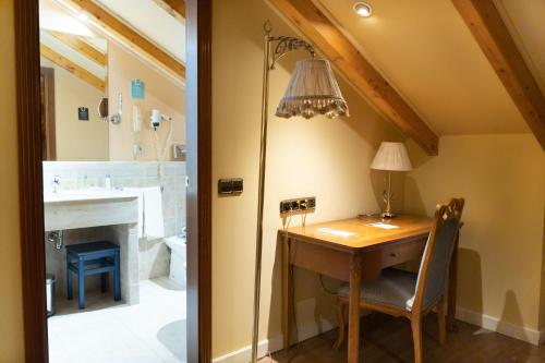 an attic room with a desk and a bathroom at Hotel Alda Mercado de Zamora in Zamora