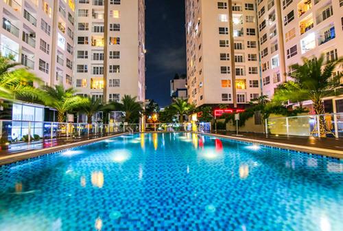 een groot blauw zwembad in een stad 's nachts bij Austin Sky Center Apartment - Near Tan Son Nhat Airport in Ho Chi Minh-stad