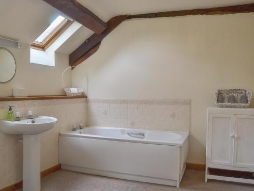 a bathroom with a bath tub and a sink at The Cider House in Bredenbury