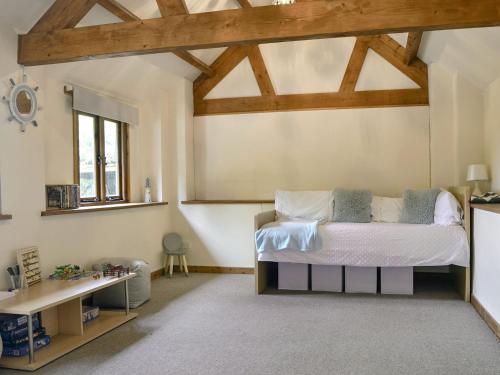 um quarto com uma cama num quarto com tectos em madeira em The Cider House em Bredenbury
