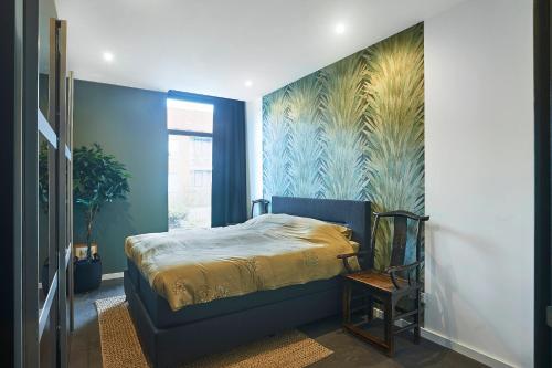 a bedroom with a bed and a wall with a mural at The Dutch Appartement Centrum Middelburg in Middelburg