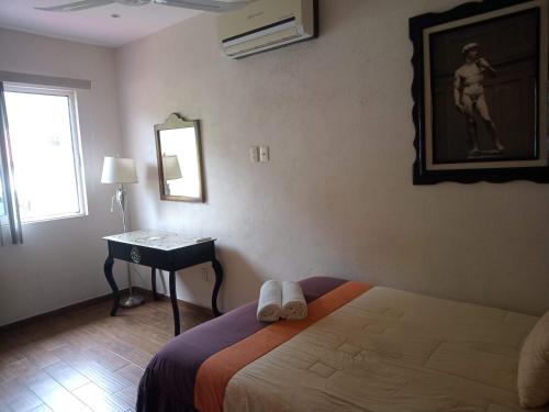 a bedroom with a bed and a table and a mirror at Villas victoria mirador in Zihuatanejo