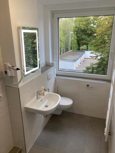 uma casa de banho com um lavatório e uma janela em Zimmervermietung38 - Mammut 1 em Salzgitter