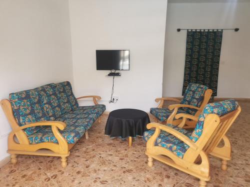 a living room with two chairs and a couch at TRANQUIL RESORT HOTEL in Brusubi