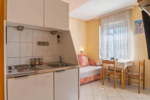 una cucina con un lavandino e un tavolo in una stanza di Villa Sladojević a Omiš (Almissa)